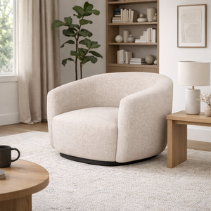 Beige armchair in a living room setting with a bookshelf and lamp.